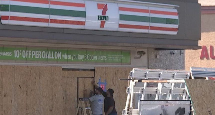 Workers board up a Las Vegas 7-Eleven